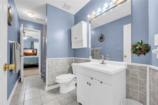 6178 Field Stone Dr, Douglasville, GA 30134 - bathroom featuring tile walls, tile patterned flooring, vanity, a wainscoted wall, and ensuite bath