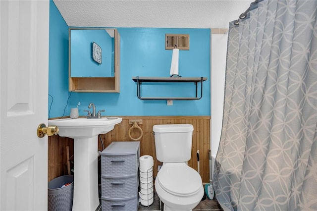 6178 Field Stone Dr, Douglasville, GA 30134 - full bathroom with wainscoting, a textured ceiling, and a shower with curtain