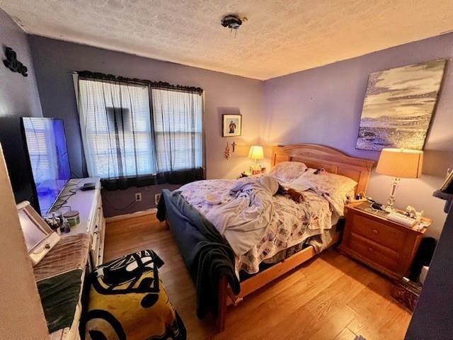 bedroom with light wood-style flooring and a textured ceiling
