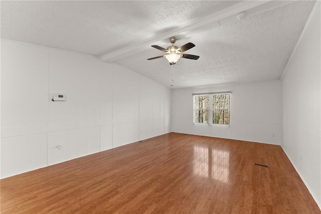 unfurnished room with wood-type flooring, vaulted ceiling with beams, ceiling fan, and a textured ceiling