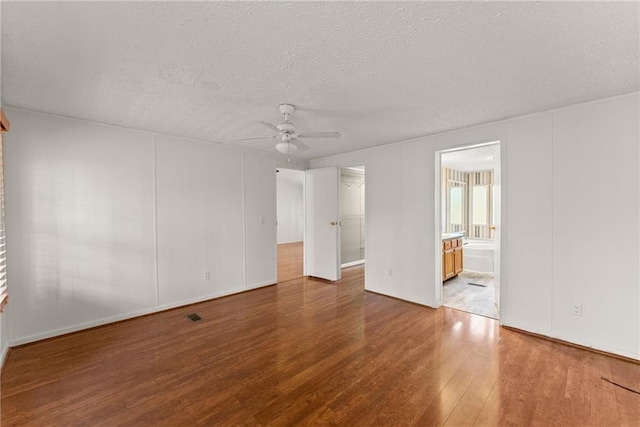 spare room with ceiling fan, hardwood / wood-style floors, and a textured ceiling