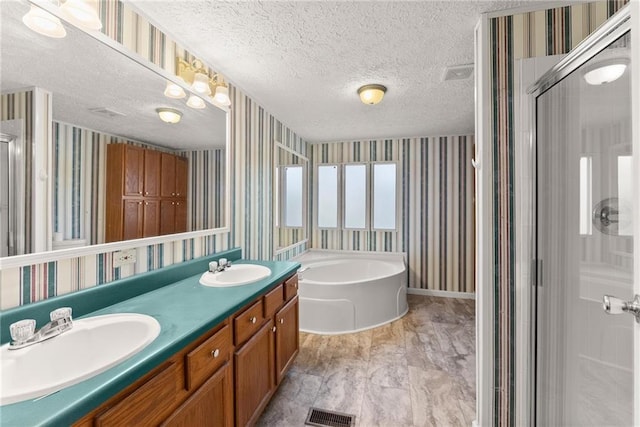 bathroom featuring vanity, separate shower and tub, and a textured ceiling