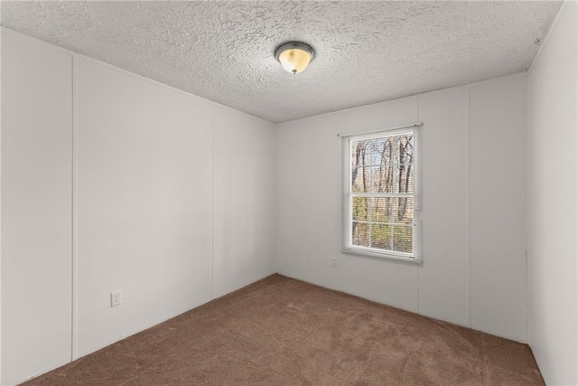 empty room with a textured ceiling and carpet flooring