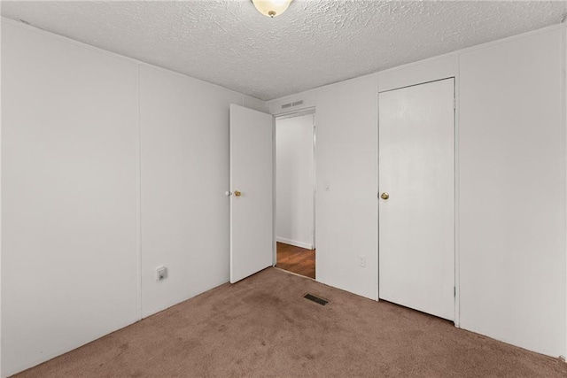 unfurnished bedroom with carpet flooring and a textured ceiling