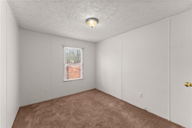 carpeted spare room featuring a textured ceiling