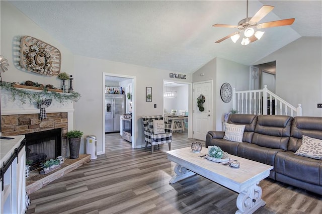 10 Alexandria Ln, Dallas, GA 30132 - living room with lofted ceiling, wood finished floors, a ceiling fan, and a stone fireplace