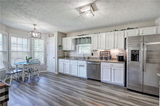 10 Alexandria Ln, Dallas, GA 30132 - kitchen featuring stainless steel appliances, light wood finished floors, white cabinetry, a textured ceiling, and light stone countertops