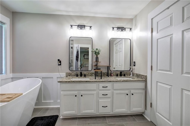 10 Alexandria Ln, Dallas, GA 30132 - full bath with a freestanding tub, double vanity, tile patterned flooring, and a wainscoted wall