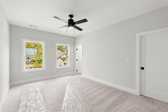 carpeted spare room featuring ceiling fan