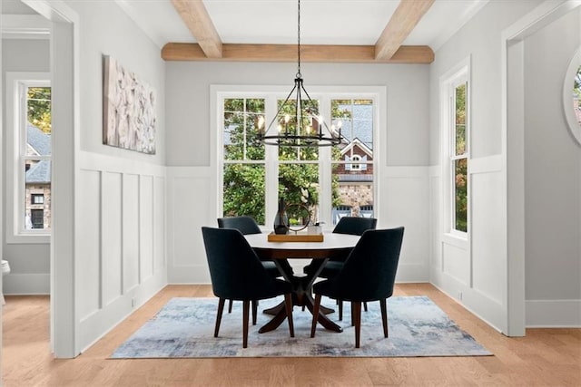 dining room featuring light hardwood / wood-style flooring, beam ceiling, and an inviting chandelier