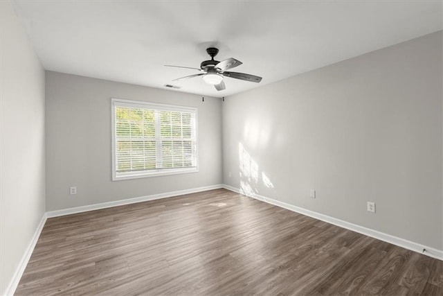 unfurnished room with ceiling fan and dark hardwood / wood-style flooring