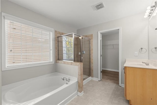 911 Queensbrooke Way, Mableton, GA 30126 - bathroom with a garden tub, vanity, a stall shower, a walk in closet, and baseboards