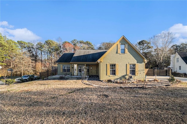 view of front of house with brick siding and fence