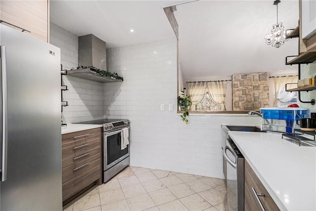 kitchen featuring wall chimney range hood, appliances with stainless steel finishes, open shelves, and a sink