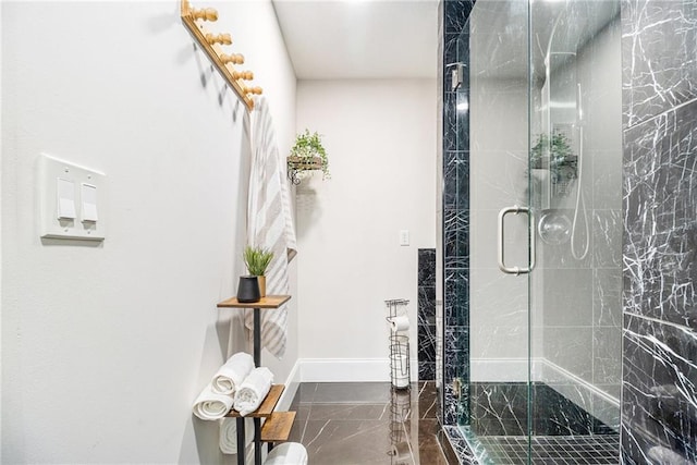 bathroom with a stall shower and baseboards