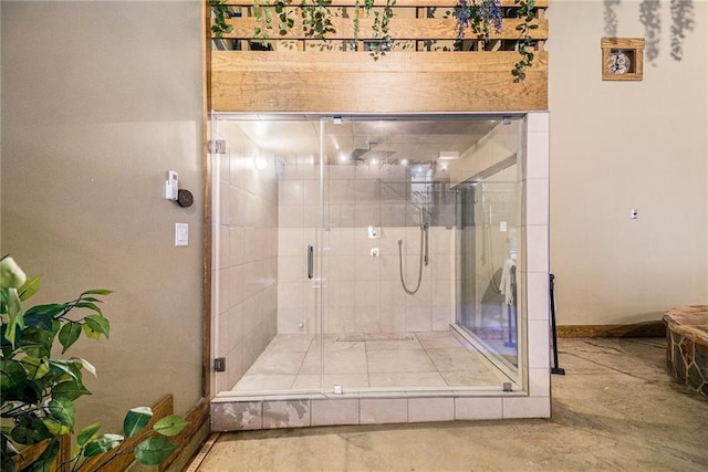 full bath featuring a shower stall and baseboards