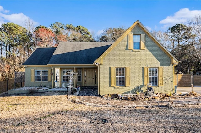 view of front of house featuring fence and brick siding