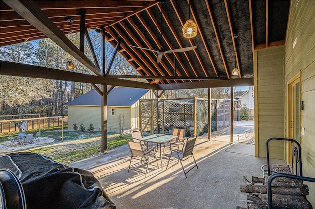 view of patio featuring outdoor dining area, an outdoor structure, and fence