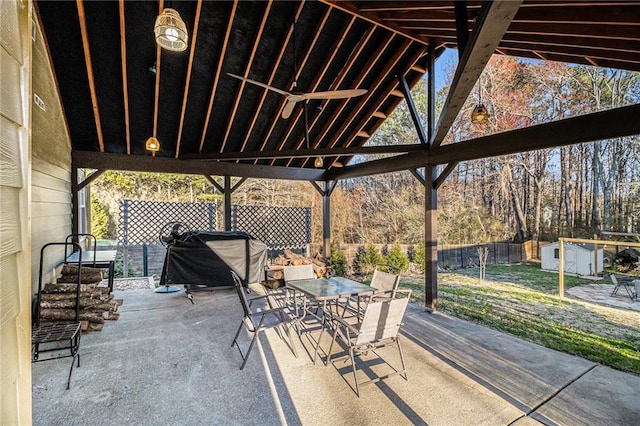 view of patio with outdoor dining area, a storage shed, area for grilling, fence, and an outdoor structure