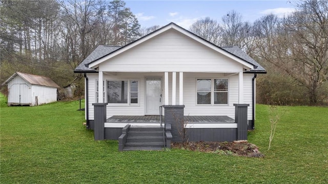 bungalow-style house with a storage shed and a front lawn