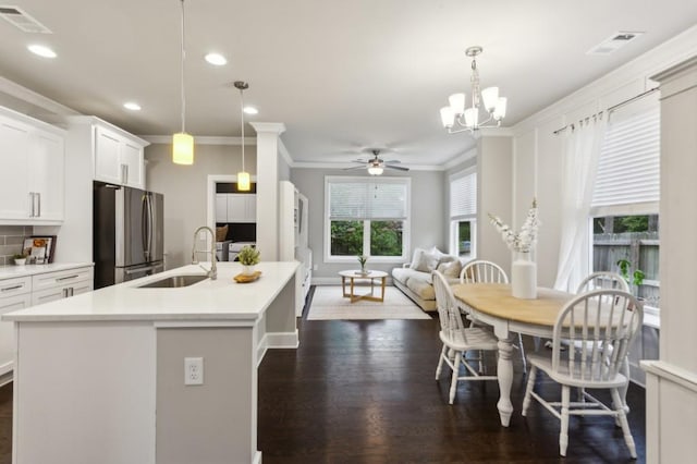 kitchen featuring freestanding refrigerator, crown molding, visible vents, and a sink
