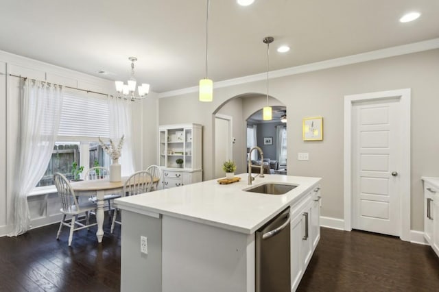 kitchen with arched walkways, dishwasher, a sink, an inviting chandelier, and dark wood-type flooring