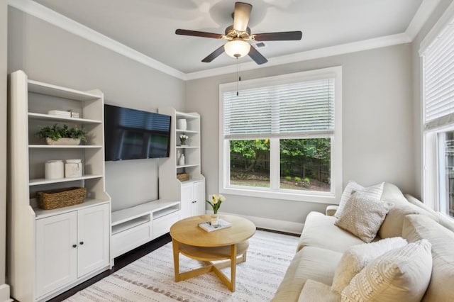 living room featuring baseboards, ceiling fan, ornamental molding, and wood finished floors