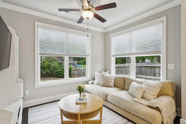 living room with a healthy amount of sunlight, baseboards, ornamental molding, and a ceiling fan