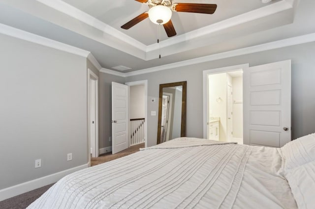 carpeted bedroom featuring visible vents, crown molding, baseboards, connected bathroom, and a tray ceiling