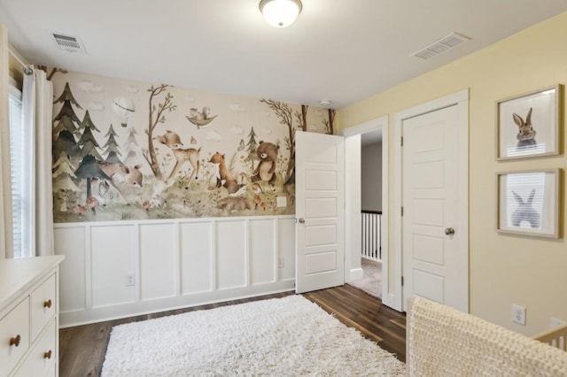 unfurnished bedroom featuring visible vents, dark wood-style flooring, and wainscoting