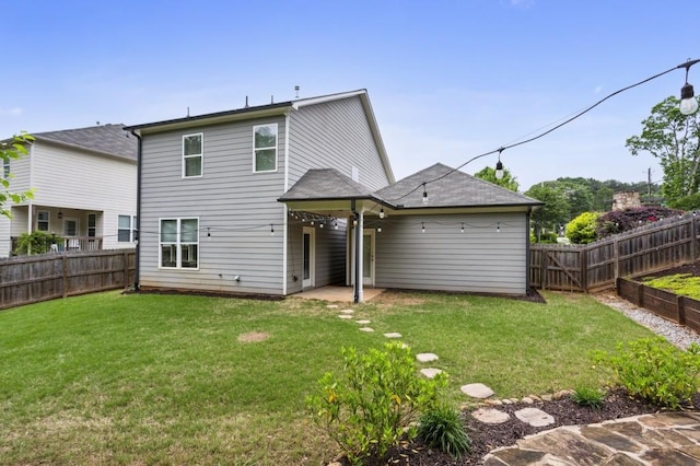 back of property with a fenced backyard, a patio area, and a yard