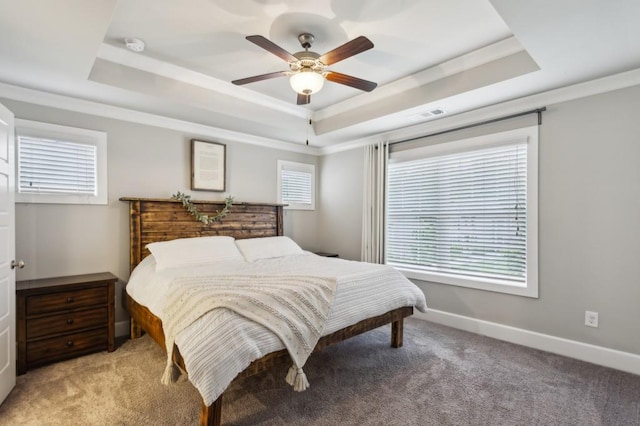 bedroom with visible vents, baseboards, light colored carpet, and a raised ceiling