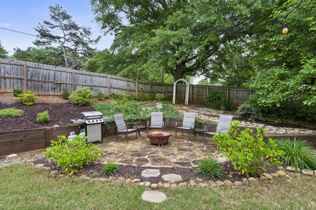 view of patio featuring a fenced backyard, grilling area, and an outdoor fire pit