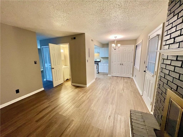 interior space with a textured ceiling, hardwood / wood-style flooring, and a chandelier