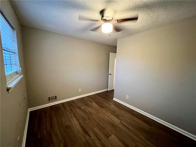 unfurnished room featuring a textured ceiling, dark hardwood / wood-style floors, and ceiling fan