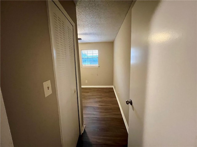 hallway featuring a textured ceiling and dark hardwood / wood-style floors