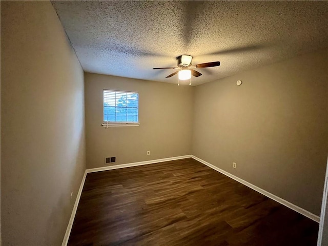 unfurnished room featuring ceiling fan, a textured ceiling, and dark hardwood / wood-style floors