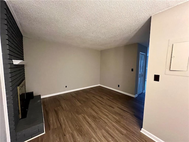 unfurnished living room with dark hardwood / wood-style floors, a textured ceiling, and a fireplace