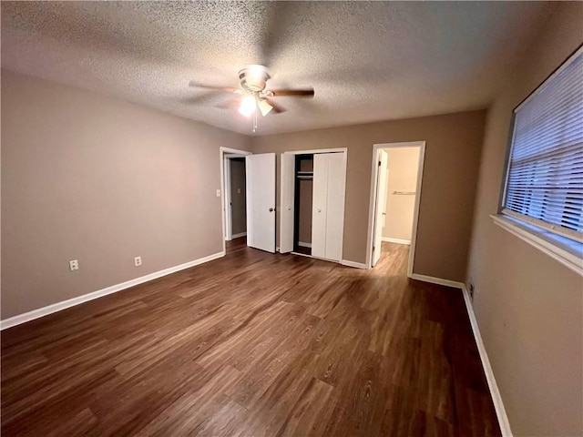 unfurnished bedroom with ceiling fan, a textured ceiling, and dark hardwood / wood-style flooring