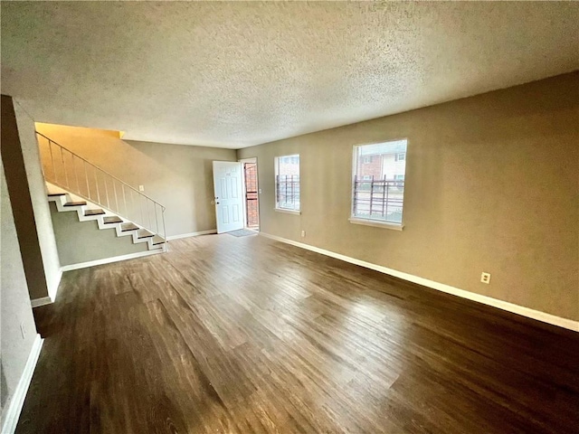 unfurnished living room featuring a textured ceiling and hardwood / wood-style flooring