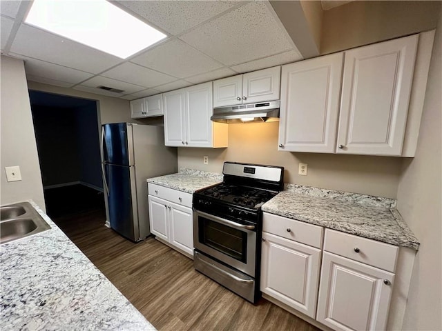 kitchen with white cabinets, stainless steel appliances, a paneled ceiling, and dark hardwood / wood-style floors