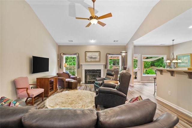3633 Gilpin Ct, Lawrenceville, GA 30044 - living room with light wood finished floors, ceiling fan, a fireplace, vaulted ceiling, and baseboards