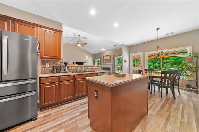 3633 Gilpin Ct, Lawrenceville, GA 30044 - kitchen with stainless steel appliances, vaulted ceiling, light wood-style floors, a sink, and a kitchen island