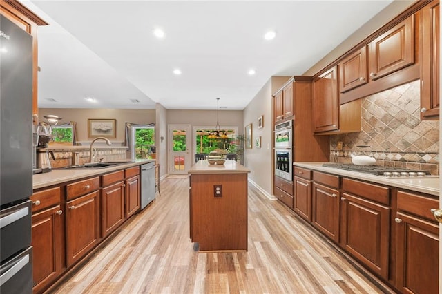 3633 Gilpin Ct, Lawrenceville, GA 30044 - kitchen featuring appliances with stainless steel finishes, a center island, light wood-type flooring, a sink, and light countertops