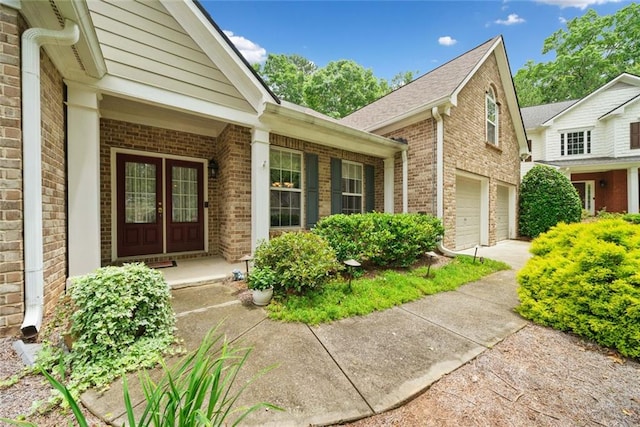 3633 Gilpin Ct, Lawrenceville, GA 30044 - view of exterior entry featuring brick siding, concrete driveway, an attached garage, a porch, and a shingled roof