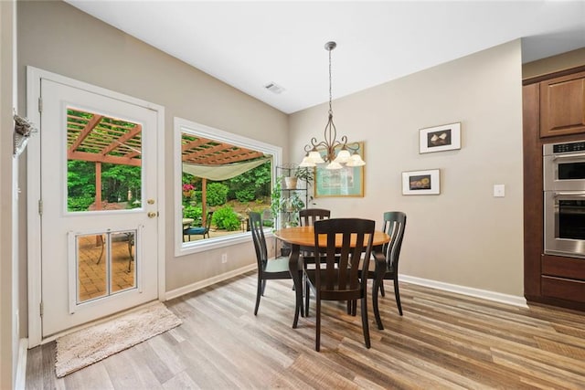 3633 Gilpin Ct, Lawrenceville, GA 30044 - dining space featuring a chandelier, baseboards, and light wood-style floors