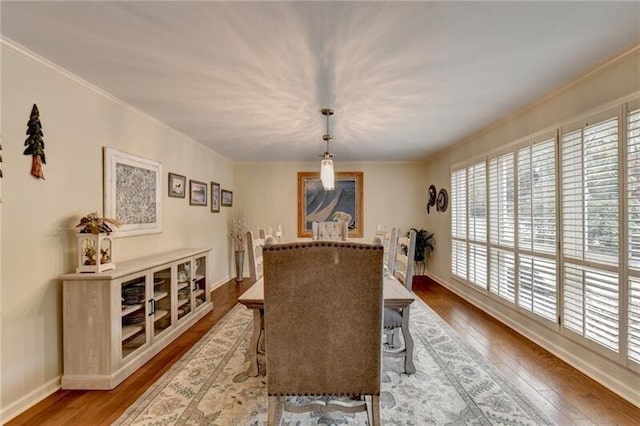 dining room with ornamental molding, baseboards, and hardwood / wood-style floors