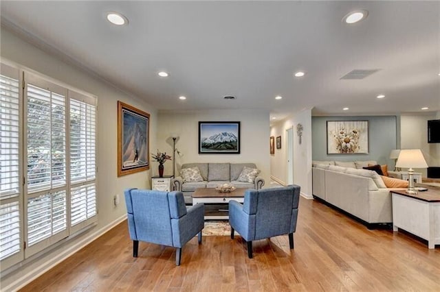 living room with recessed lighting, visible vents, baseboards, light wood finished floors, and crown molding