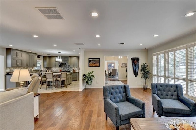 living room featuring recessed lighting, a healthy amount of sunlight, visible vents, and light wood finished floors