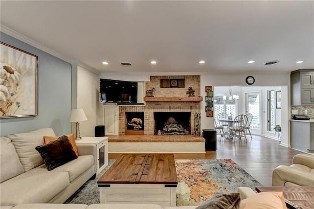 living room featuring a fireplace, ornamental molding, wood finished floors, and recessed lighting